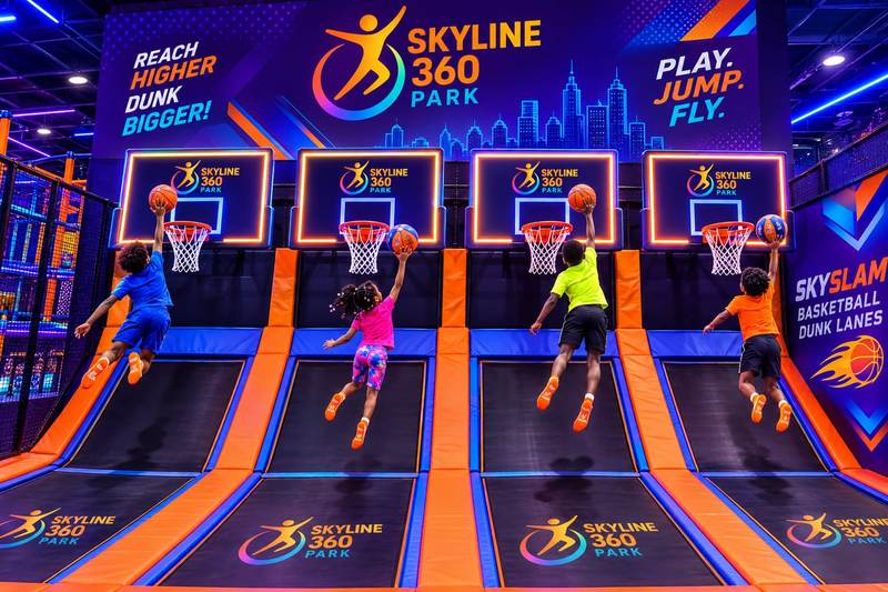Kids slam dunking on the SkySlam trampoline dunk lanes
